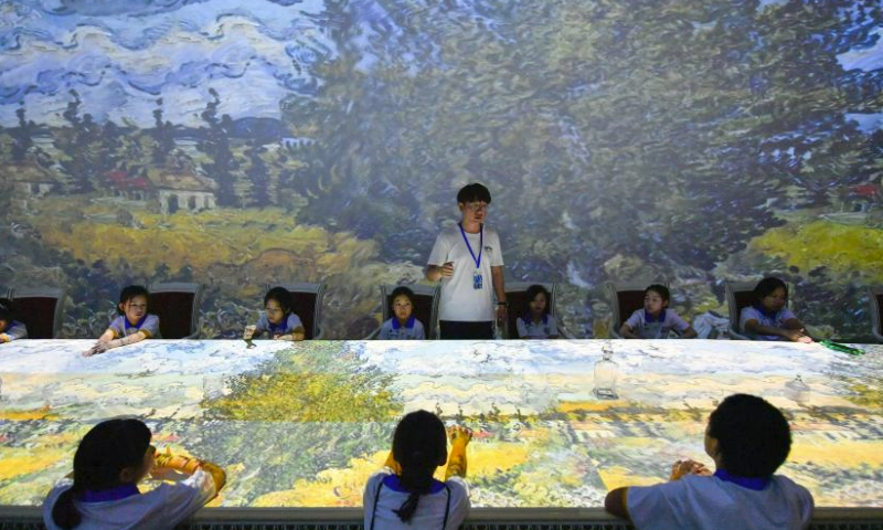 Students watch an immersive show of an artwork at the Tianjin Digital Art Museum in Tianjin, north China, July 30, 2023. During the summer vacation, the National Maritime Museum of China and the Tianjin Digital Art Museum jointly offered students with a study camp themed on ocean and art. Altogether 22 students from Beijing, Tianjin and Hebei Province learnt knowledge of ocean and nature and got in touch with digital art during the camp. (Xinhua/Sun Fanyue)