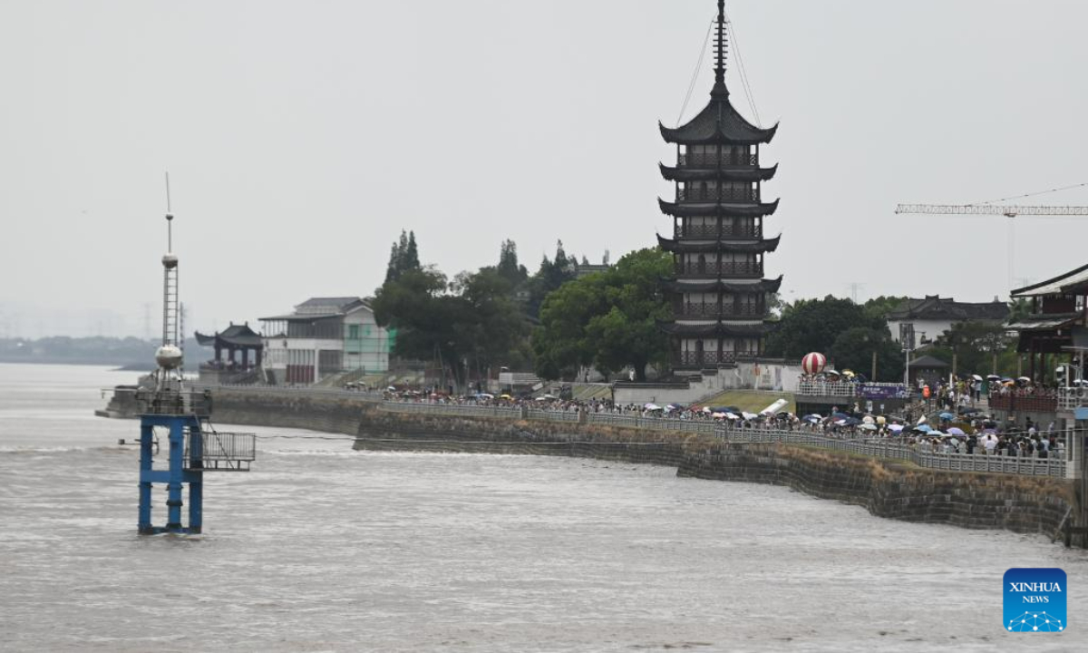 People watch the waves caused by the Qiantang River tidal bore in Yanguan Township of Haining City, east China's Zhejiang Province, Aug 4, 2023. Photo:Xinhua