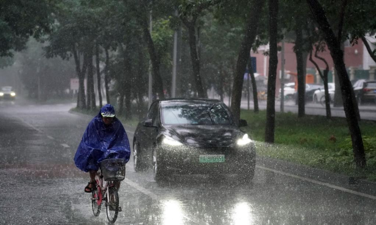 A resident rides a bike in the rain on a road in Haidian District, Beijing, capital of China, on July 29, 2023. Impacted by Typhoon Doksuri, the fifth typhoon of this year, heavy rainfall has hit regions in northern China, including Beijing, Hebei and Shandong. Photo:Xinhua