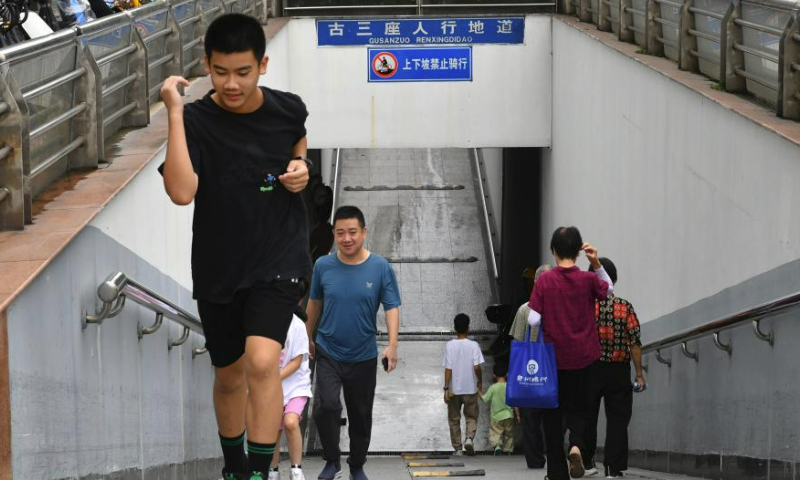 Citizens pass through an underpass in Fuzhou, southeast China's Fujian Province, July 30, 2023. Fuzhou has seen its urban life gradually back to normal after typhoon Doksuri swept through the city. (Xinhua/Wei Peiquan)