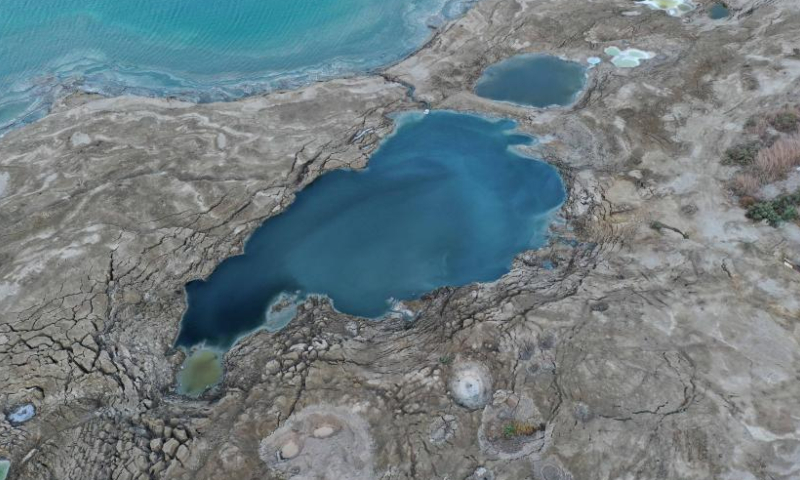 This aerial photo taken on Aug. 6, 2023 shows sinkholes on the shore of the Dead Sea near Ein Gedi beach, Israel. Statistics showed that the Dead Sea had been shrinking at an alarming pace, its water level dropping by 1.2 meters each year. As the water receded, a barren landscape of salt rock and numerous sinkholes appeared. (Photo by Gil Cohen Magen/Xinhua)