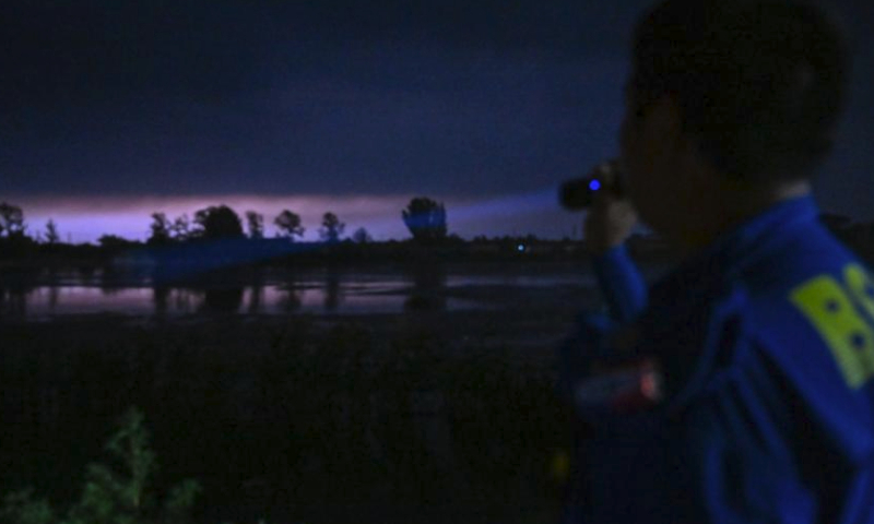 A member of the Blue Sky Rescue Team's Tianjin Jinghai branch checks potential safety hazards on a dam along the Daqing River in Taitou Town of Jinghai District, north China's Tianjin Municipality, Aug. 4, 2023. All residents of 18 villages under the administration of the Taitou Town have been evacuated to safety before noon of Aug. 3. All the town's flood rescue teams including members of the armed police force in Tianjin, the Blue Sky Rescue Team, local officials and rescue workers are standing by to brace for flooding from upstream river which is expected to arrive here on Aug. 4. (Xinhua/Sun Fanyue)