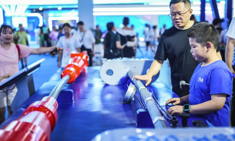 People watch Guizhou's self-developed steel cables for bridge construction during the first Guizhou Science and Technology Festival in Guiyang, southwest China's Guizhou Province, Aug. 5, 2023. The first Guizhou Science and Technology Festival kicked off at Guiyang International Conference and Exhibition Center on Saturday and will last till Aug. 9. (Xinhua/Tao Liang)