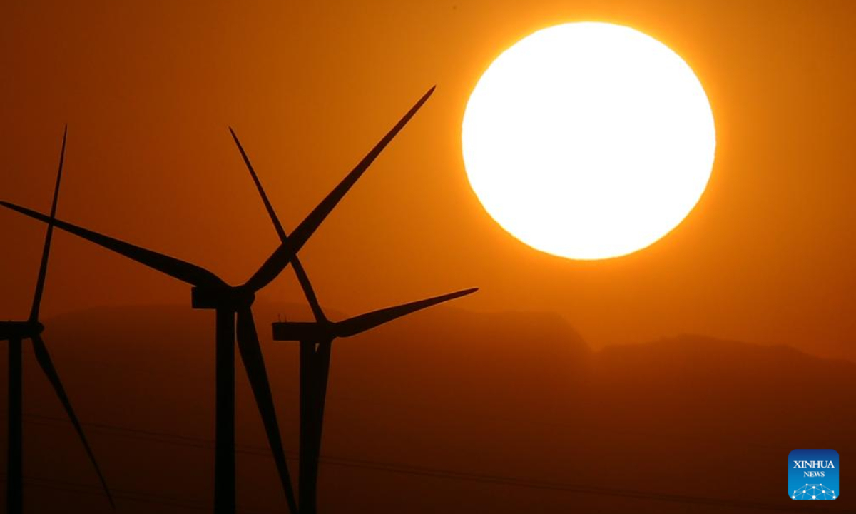 Wind turbines are silhouetted against the sunset in Hurghada, Egypt, on Aug 4, 2023. Photo:Xinhua