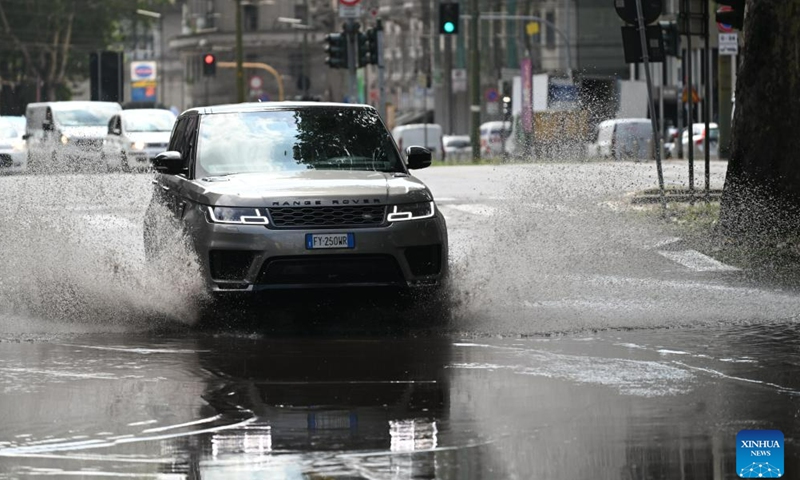 A vehicle drives through a flooded street after thunderstorms in Milan, Italy, on July 25, 2023. While the southern two-thirds of Italy struggled under the oppressive heat, most of the northern area was pelted by thunderstorms and over-sized hail. Media reports said the emergency services in Milan had responded to more than 200 requests for help related to flooding, fallen trees, and damage to cars and homes, since a severe storm hit the city late Monday. (Str/Xinhua)