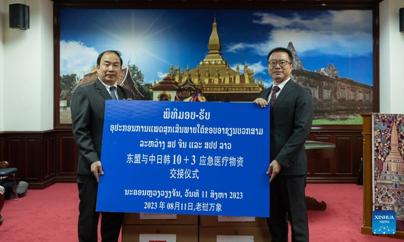 Wang Chang (R), charge d'affaires of the Chinese Embassy in Laos, and Deputy Minister of the Lao Ministry of Health Phaivanh Keopaseuth attend a handover ceremony of emergency medical supplies under ASEAN plus China, Japan and South Korea (ASEAN+3) framework between China and Laos, in Vientiane, Laos, Aug. 11, 2023. (Photo by Kaikeo Saiyasane/Xinhua)