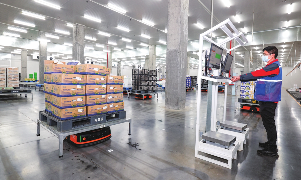 Robots shuttle among shelves according to staff commands, sorting vegetables, fruits and other fresh products at a food logistics center in Xiangyang, Central China's Hubei Province on August 1, 2023. The use of robots increases the center's sorting efficiency by 40 percent, which helps meet consumer demand for fresh produce in the summer. Photo: VCG