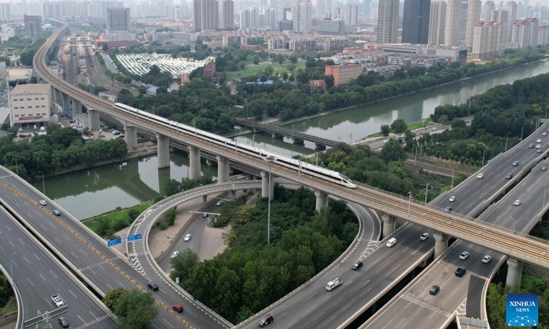 This aerial photo taken on July 20, 2023 shows a train operating on the Beijing-Tianjin Intercity Railway in the urban area of north China's Tianjin. The Beijing-Tianjin Intercity Railway celebrated its 15th anniversary of opening Tuesday. As the first high-speed railway (HSR) with a design speed of 350 km per hour in China, the Beijing-Tianjin Intercity Railway carried a total of 340 million passengers since it entered operation.(Photo: Xinhua)