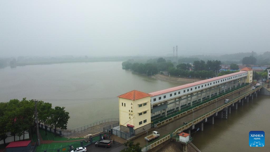 This aerial photo taken on Aug. 1, 2023 shows flood passing through a flood gate of Yongding New River, an artificial waterway in the lower reaches of Yongding River, in north China's Tianjin Municipality. North China's Tianjin Municipality said Tuesday it had relocated more than 35,000 people from areas prone to flooding by the Yongding River, which has swollen amid intense rainfall.(Photo: Xinhua)