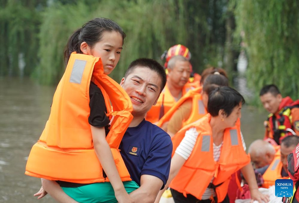 People head towards a transshipment point after taking a rescue boat in Fangshan District of Beijing, capital of China, Aug. 2, 2023. Some parts of the Fangshan District suffered from flood and geological disasters caused by recent rainstorms in the capital city. A rescue team comprised of firefighters, medical workers and volunteers set out to evacuate people afflicted by rainstorms and floods in Pinggezhuang Village of Liulihe Town on Wednesday.(Photo: Xinhua)