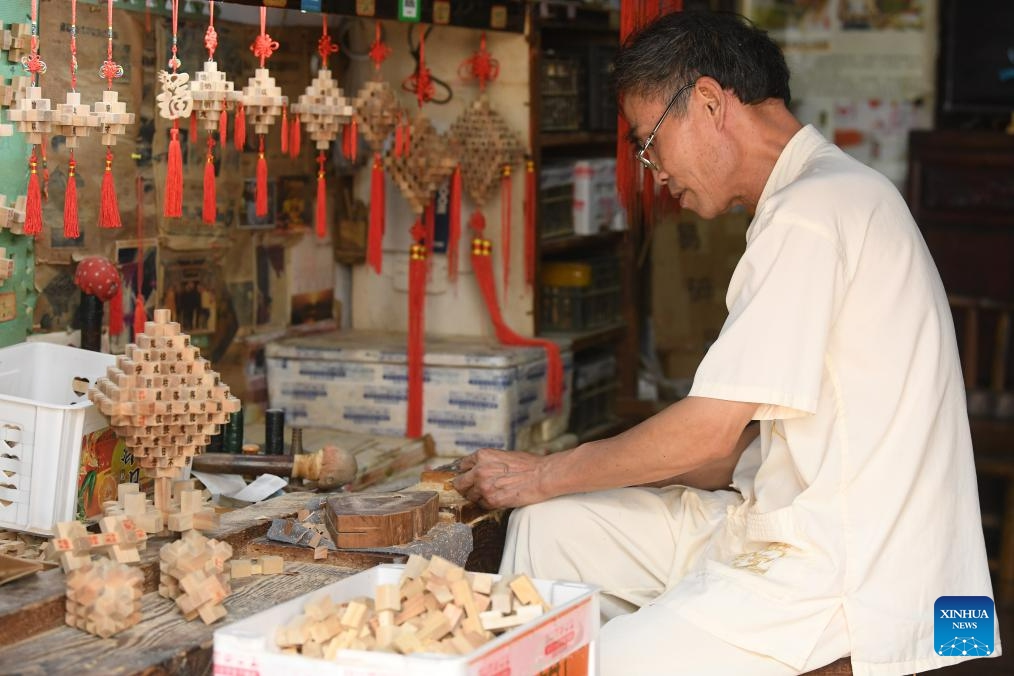 An intangible cultural heritage inheritor makes Kong Ming Lock, a traditional educational toy, in Zhuge Village of Lanxi City, east China's Zhejiang Province, Aug. 1, 2023. The Zhuge Village, a historic gem with over 300 ancient buildings dating back to Ming and Qing dynasties (1368-1911), is home to descendents of Zhuge Liang, a renowned military strategist in the Three Kingdom Period (220-280). (Photo: Xinhua)