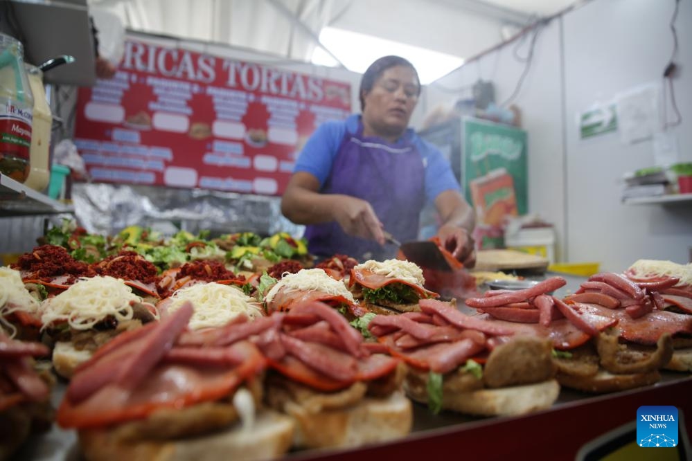 A chef makes torta during the 18th annual Torta Fair in Mexico City, capital of Mexico, Aug. 2, 2023. Torta is known as a traditional sandwich in Mexico and is welcomed by local people. (Photo: Xinhua)