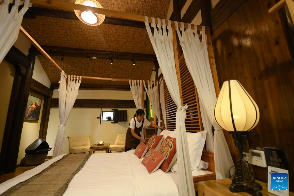 A staff member cleans up a room at a homestay in Zhuge Village of Lanxi City, east China's Zhejiang Province, Aug. 1, 2023. The Zhuge Village, a historic gem with over 300 ancient buildings dating back to Ming and Qing dynasties (1368-1911), is home to descendents of Zhuge Liang, a renowned military strategist in the Three Kingdom Period (220-280). The village has made concerted efforts to preserve the ancient heritages and develop tourism, receiving over 500,000 visitors annually.(Photo: Xinhua)