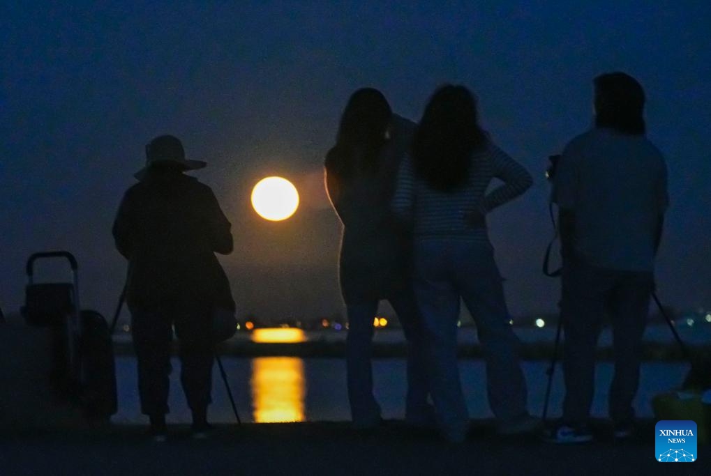 People watch a supermoon in Vancouver, Canada, on Aug. 1, 2023.(Photo: Xinhua)