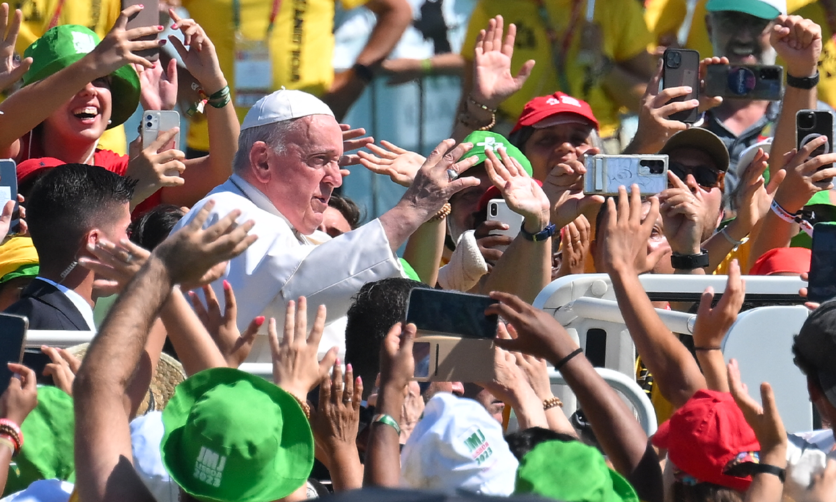 Pope Francis waves from the popemobile with volunteers of World Youth Day (WYD) in Alges, 10 kilometers from Lisbon, on August 6, 2023. Pope Francis celebrated an open-air mass before a huge crowd at a waterside park near Lisbon to wrap up the WYD, the largest Catholic gathering in the world, created in 1986 by John Paul II. Around 1.5 million people attended the service at the Parque Tejo park on the eastern outskirts of the Portuguese capital, the Vatican said. Photo: AFP