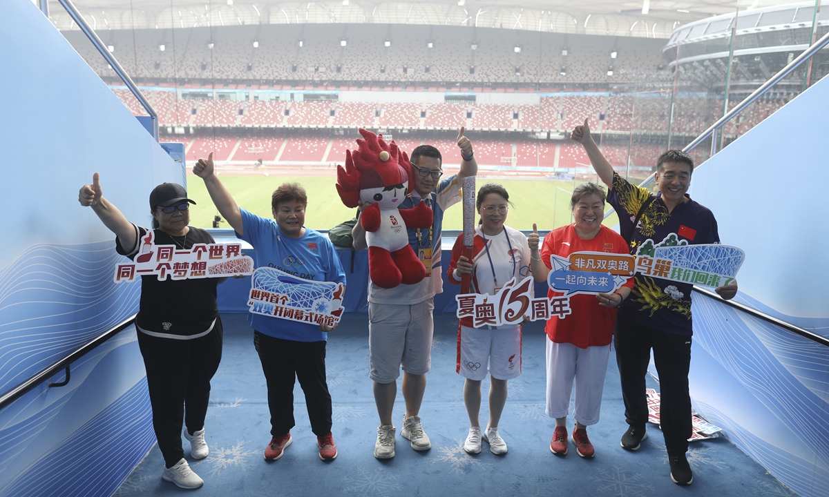 Representatives of the Beijing 2008 Olympic/Paralympic Games torch-bearers, volunteers and staff members pose for photographs inside the National Stadium, also known as the Bird's Nest, in Beijing on August 8, 2023. An exhibition was held to celebrate the 15th anniversary of the Beijing Olympic Games, which opened on August 8, 2008, at the Bird's Nest, the main venue for the 2008 Games. It also hosted the opening and closing ceremonies of the 2022 Winter Olympics. Photo: VCG