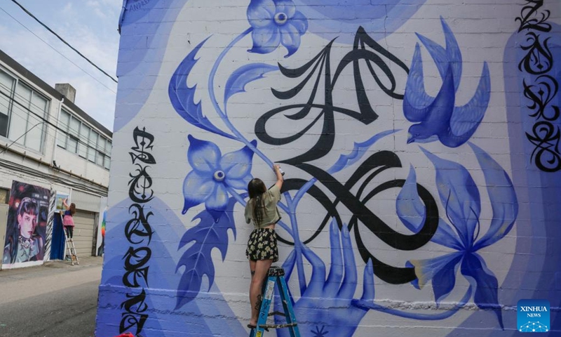 An artist works on her mural during the annual Vancouver Mural Festival in Vancouver, British Columbia, Canada, on Aug. 7, 2023. Mural artists from across the world participated in the annual ten-day festival, turning the urban space into an art gallery.(Photo: Xinhua)