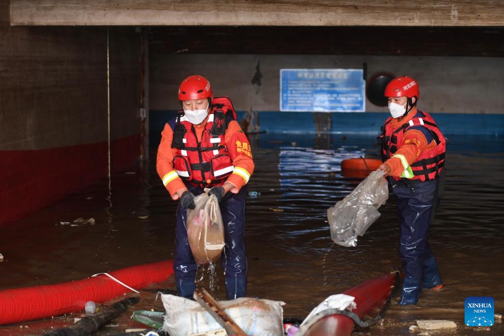 Rescuers clear garbage as they perform drainage operation at an underground parking area in Zhuozhou, north China's Hebei Province, on Aug. 7, 2023. More than 800 rescuers redeployed from Tangshan, Handan, Hengshui and other cities of the province have been working around the clock in the most seriously flooded areas of Zhuozhou, trying to put life back to normal as soon as possible.(Photo: Xinhua)