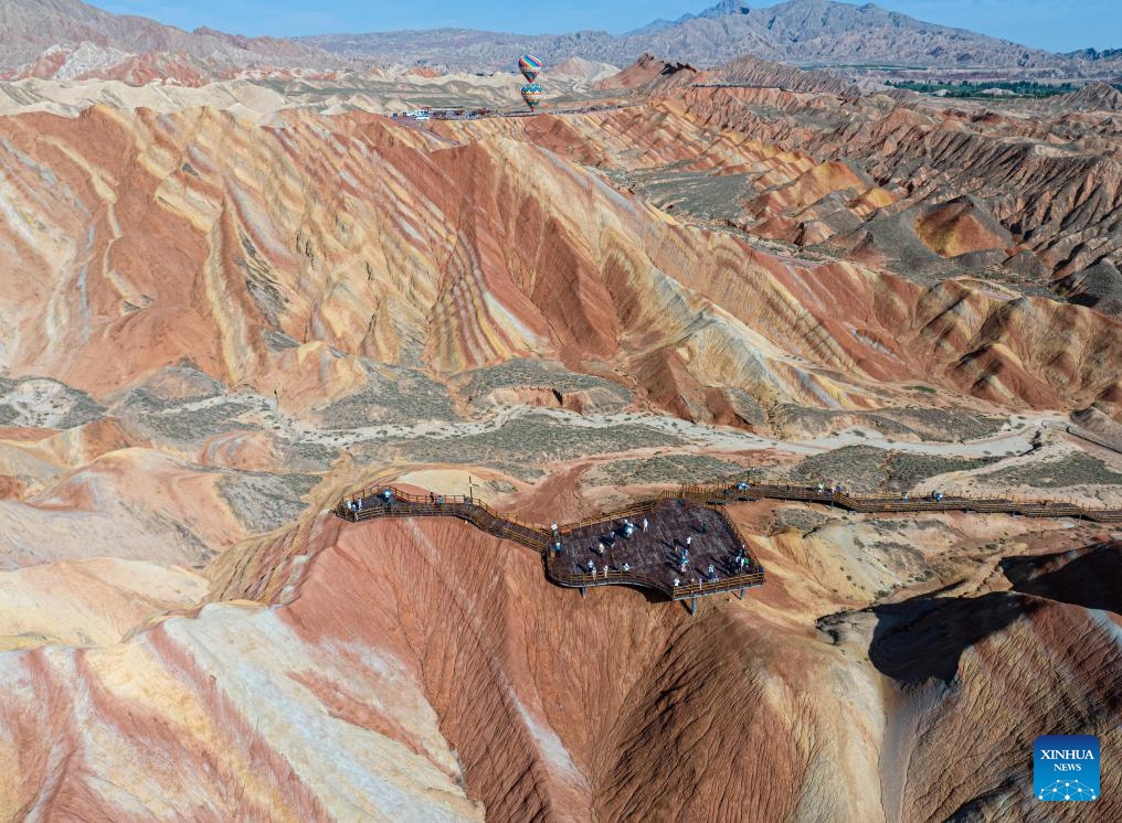 This aerial photo taken on Aug. 7, 2023 shows a view of Danxia landform at Danxia National Geological Park in Zhangye, northwest China's Gansu Province. Boasting a unique type of geomorphology formed from red-colored sandstones and characterized by steep cliffs, the Danxia National Geological Park has attracted an average of over 35,000 visitors daily since August.(Photo: Xinhua)