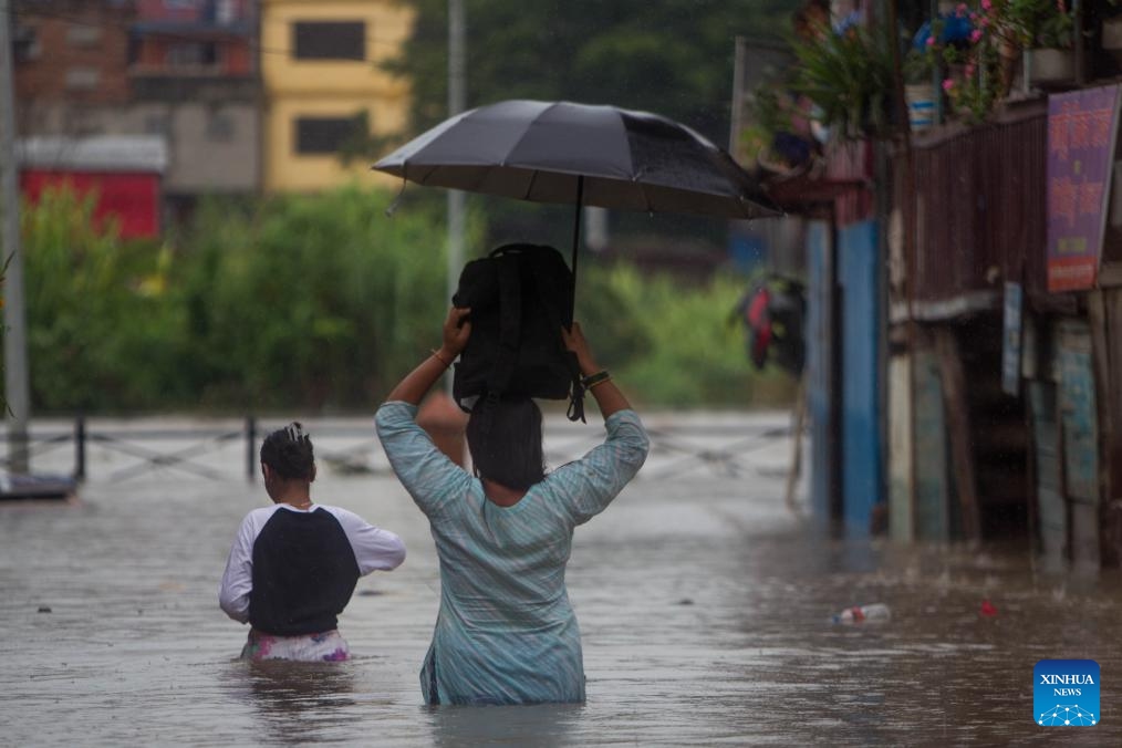 People wade through flood water in Kathmandu, Nepal on Aug. 8, 2023. Monsoon rains have caused floods in various parts of Kathmandu.(Photo: Xinhua)