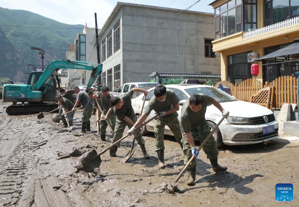 Volunteers clean up silt on the road in Liujiahe Village, Sanpo Town, Laishui County, in north China's Hebei Province, Aug. 8, 2023. Affected by Typhoon Doksuri, Laishui County suffered heavy rainfall recently and some villages encountered traffic and communication disruptions. At present, the local authorities are mending infrastructure damaged by flood to bring life back to normal as soon as possible.(Photo: Xinhua)