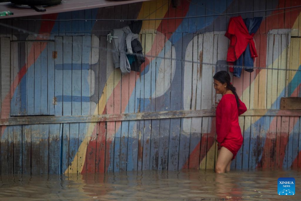 A woman wades through flood water in Kathmandu, Nepal on Aug. 8, 2023. Monsoon rains have caused floods in various parts of Kathmandu.(Photo: Xinhua)