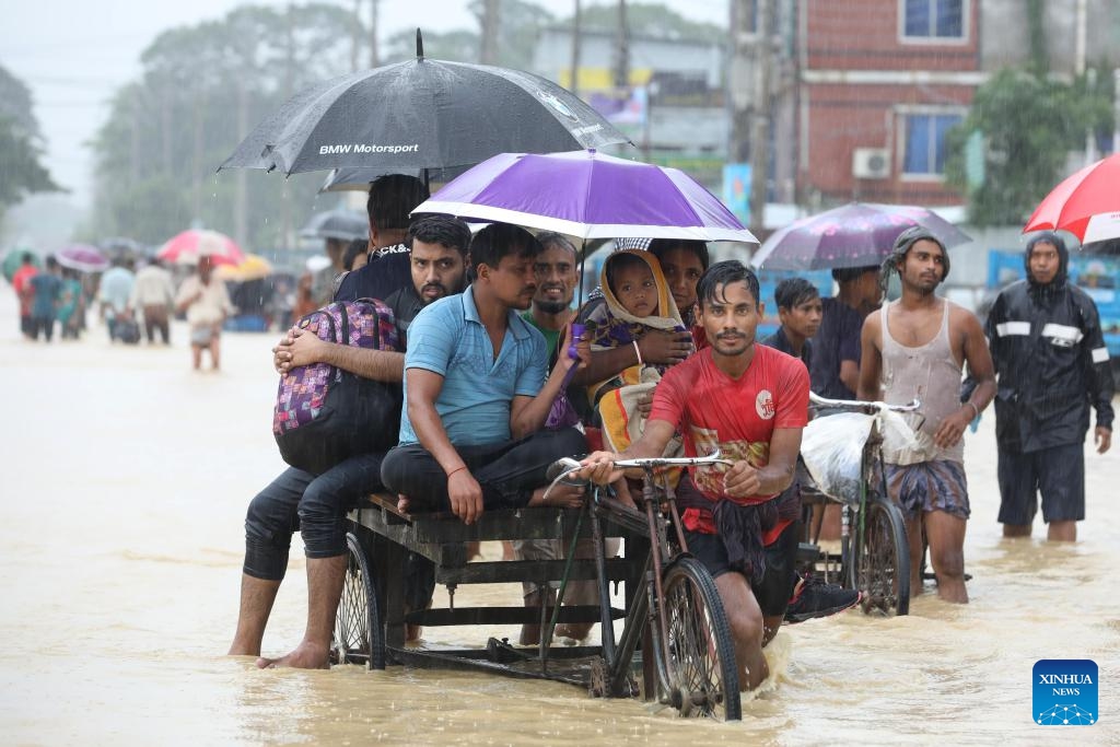 A man pushes a tricycle transferring people through a flooded road in Chattogram, Bangladesh, on Aug. 9, 2023. Bangladeshi soldiers were deployed on Tuesday to the country's Chattogram region, some 240 km southeast of the capital Dhaka, to tackle its worsening situation of torrential rains. (Photo: Xinhua)