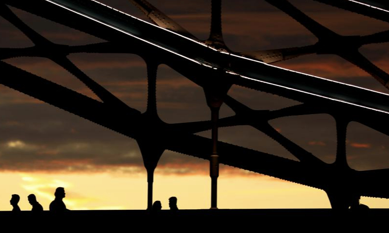 This photo taken on Aug. 13, 2023 shows people walking on Tower Bridge after sunset in London, Britain. (Xinhua/Li Ying)