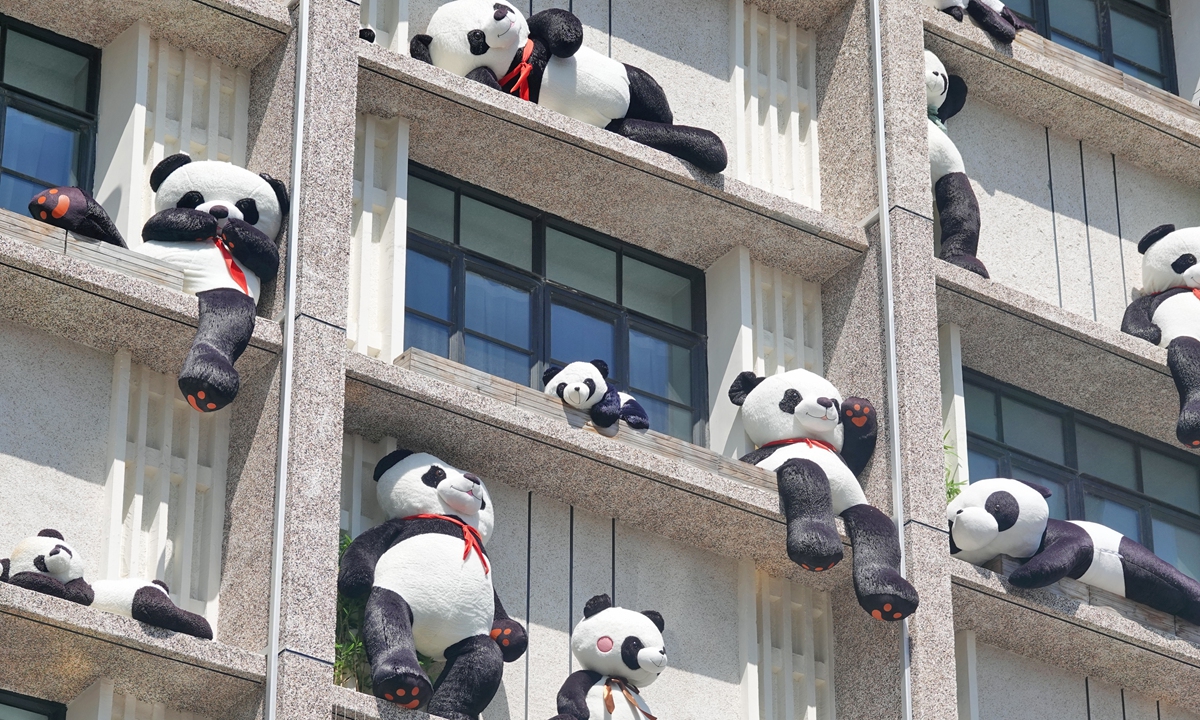 Plush pandas decorate the exterior wall of a hotel in Yantai, East China's Shandong Province, on August 10, 2023. Nearly 100 plush pandas of various kinds 