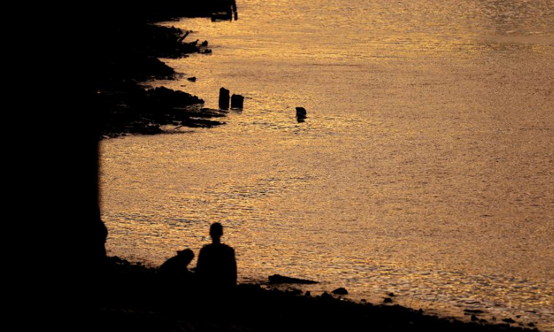 This photo taken on Aug. 13, 2023 shows people along the River Thames after sunset in London, Britain. (Xinhua/Li Ying)