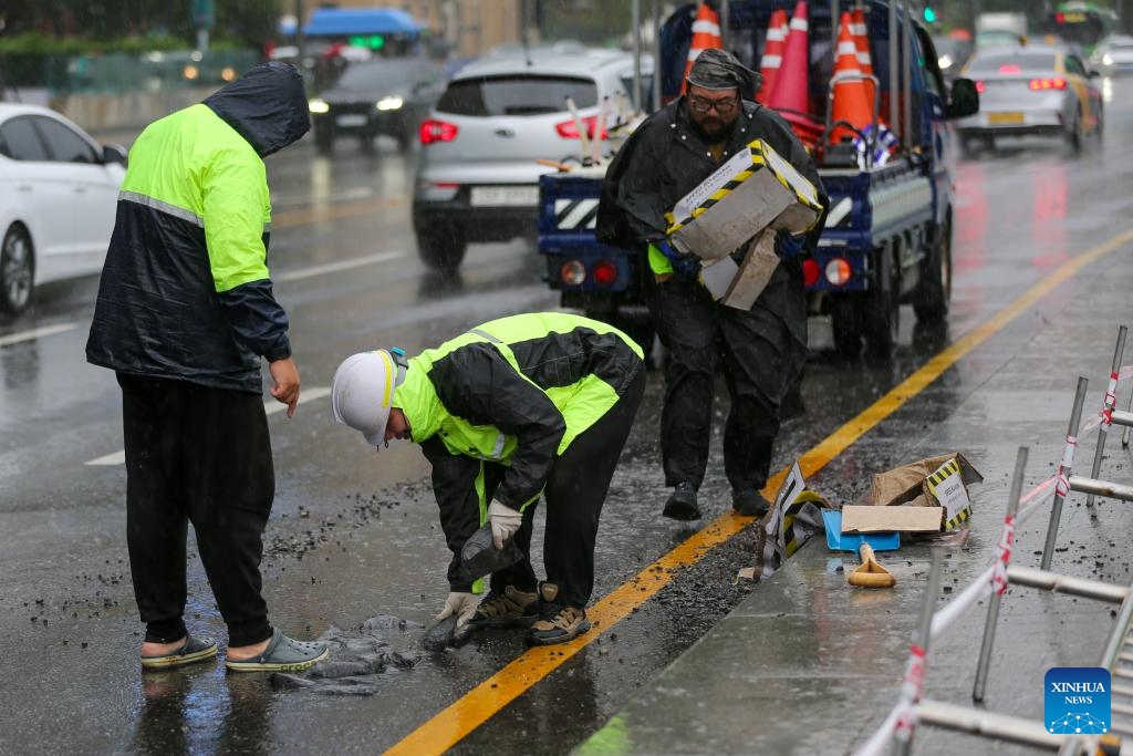 Workers repair a street surface in the rain brought by Typhoon Khanun in Seoul, South Korea, Aug. 10, 2023. Typhoon Khanun brought powerful wind and heavy rain to parts of South Korea.(Photo: Xinhua)