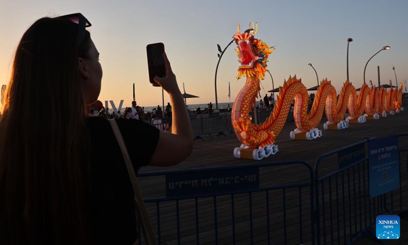 A visitor takes photos at the Chinese Lantern Exhibition in Tel Aviv, Israel, on Aug. 9, 2023. The Chinese Lantern Exhibition in Tel Aviv features several sets of lanterns which are crafted by a team from Zigong City of southwest China's Sichuan Province. (Photo: Xinhua)