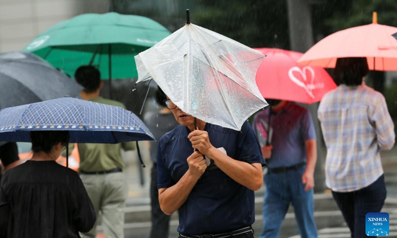 People walk on a street in the rain brought by Typhoon Khanun in Seoul, South Korea, Aug. 10, 2023. Typhoon Khanun brought powerful wind and heavy rain to parts of South Korea.(Photo: Xinhua)