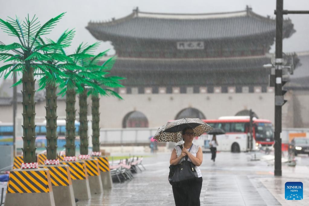 A woman walks at the Gwanghwamun Square in the rain caused by Typhoon Khanun in Seoul, South Korea, Aug. 10, 2023. Typhoon Khanun brought powerful wind and heavy rain to parts of South Korea.(Photo: Xinhua)