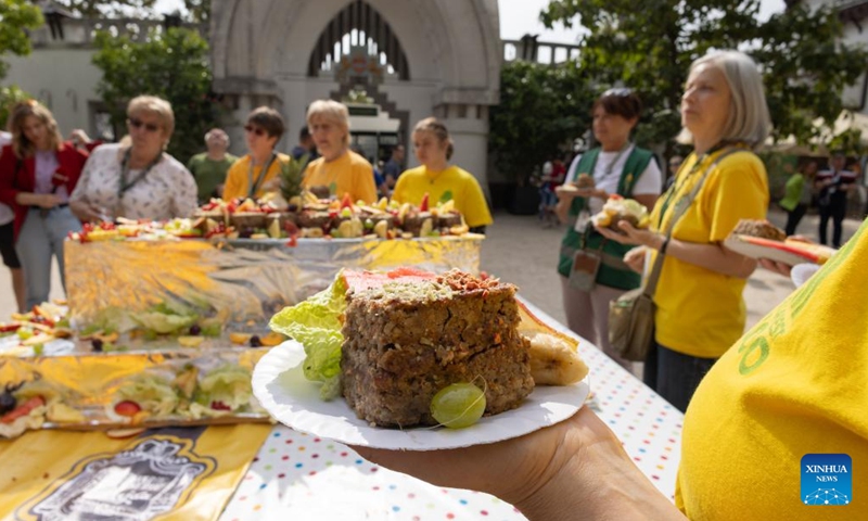 People taste a special cake edible for both humans and animals at Budapest Zoo in Budapest, Hungary, Aug. 9, 2023. Budapest Zoo celebrated its 157th anniversary on Wednesday.(Photo: Xinhua)