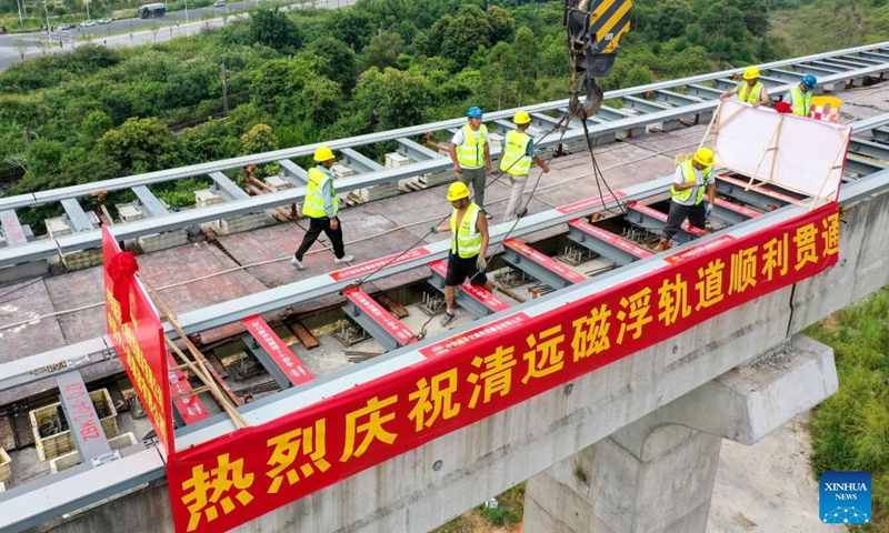 This aerial photo taken on Aug. 10, 2023 shows workers laying the last 10-meter-long maglev track at the construction site of a medium-and-low speed maglev line in Qingyuan City, south China's Guangdong Province. The last 10-meter-long maglev track was laid on the Qingyuan maglev tourism line on Thursday, marking the completion of the track-laying work for the first medium-and-low speed maglev line in the province.(Photo: Xinhua)