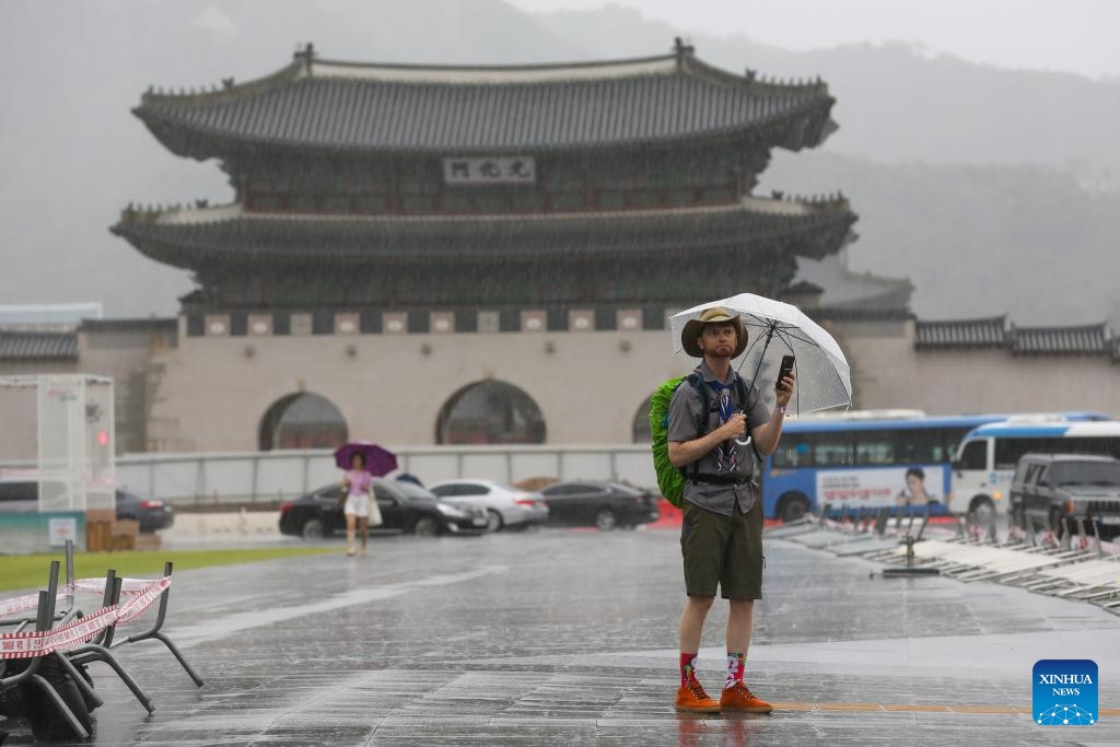 A man walks at the Gwanghwamun Square in the rain brought by Typhoon Khanun in Seoul, South Korea, Aug. 10, 2023. Typhoon Khanun brought powerful wind and heavy rain to parts of South Korea.(Photo: Xinhua)