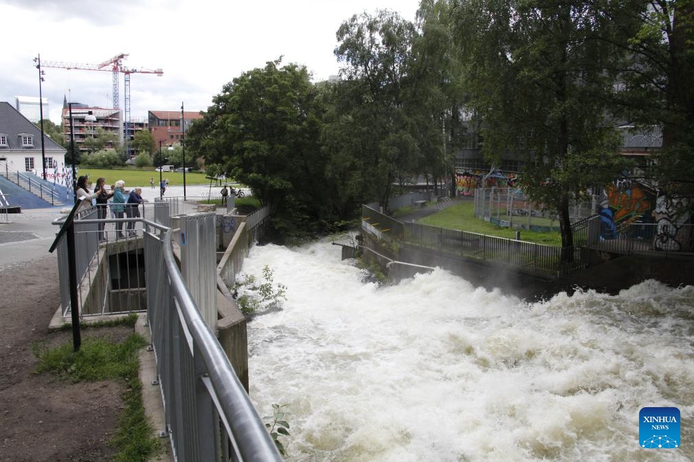 This photo taken on Aug. 10, 2023 shows water flooding down the Aker River in the downtown area of Oslo, capital of Norway. Storm Hans has been battering Norway since Monday, resulting in over 4,000 reports of damages to properties.(Photo: Xinhua)