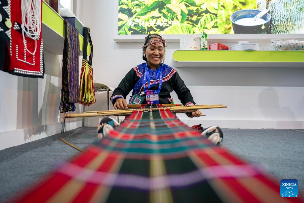 An exhibitor presents embroidery skills of Va ethnic group at the seventh China-South Asia Expo in Kunming, southwest China's Yunnan Province, Aug. 16, 2023. The seventh China-South Asia Expo kicked off Wednesday in Kunming. More than 30,000 exhibitors, representatives and guests from 85 countries and regions, and international organizations, are expected to attend both online and offline activities during the five-day expo.(Photo: Xinhua)