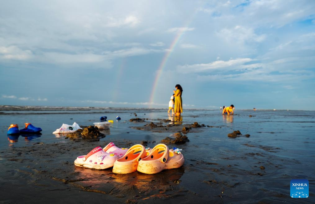 Tourists have fun before the sunrise at Jintan beach in Dongxing, south China's Guangxi Zhuang Autonomous Region, Aug. 14, 2023. Jintan beach, which is located in the southern part of the Wanwei Island, has a coastline of 15 kilometers and is named after its golden sand color.(Photo: Xinhua)