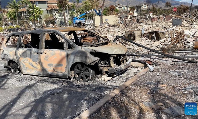 The photo taken with a mobile phone on Aug. 14, 2023 shows a vehicle destroyed in a wildfire in Lahaina town, Maui Island, Hawaii, the United States. The death toll from the Maui wildfires reached 99, authorities said Monday. Lahaina, a historic town on Maui Island, is facing a dire and immediate housing shortage and a serious threat of long-term displacement following the deadliest U.S. wildfire in over a century, reported The Washington Post on Monday.(Photo: Xinhua)