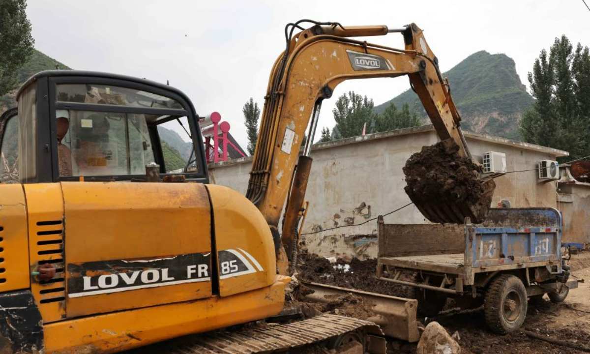 A worker drives an excavator to clean up silt at Pingyu Village of Laishui County, north China's Hebei Province, Aug 17, 2023. Laishui County has suffered heavy rainfall due to the impact of Typhoon Doksuri recently. Photo:Xinhua