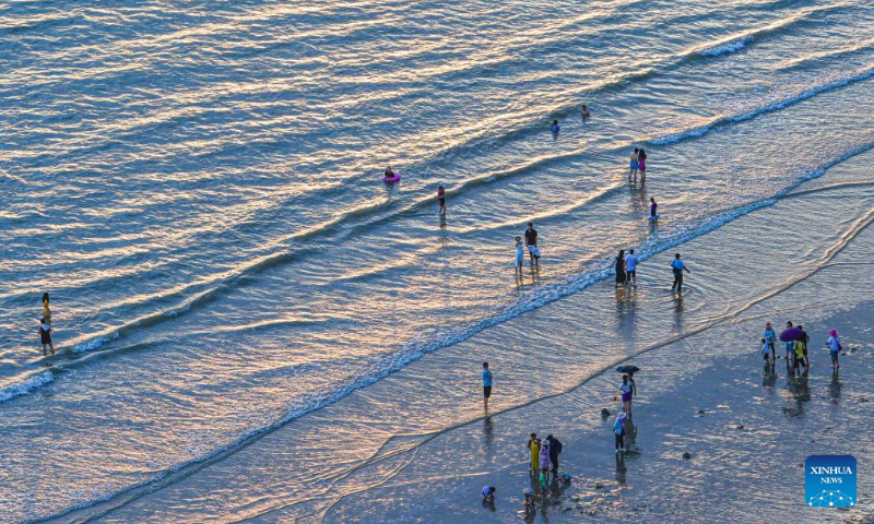 Tourists enjoy themselves by the seaside of Sanya Bay in Sanya, south China's Hainan Province, Aug. 30, 2023. (Xinhua/Pu Xiaoxu)