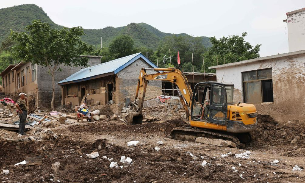 A worker drives an excavator to clean up silt at Pingyu Village of Laishui County, north China's Hebei Province, Aug 17, 2023. Laishui County has suffered heavy rainfall due to the impact of Typhoon Doksuri recently. Photo:Xinhua