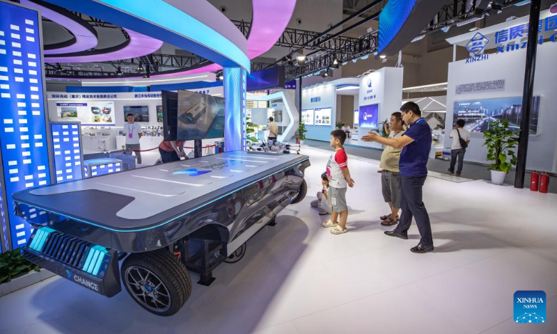 Visitors look at a skateboard chassis used on smart vehicles at the venue for 2023 Smart China Expo in southwest China's Chongqing, Sept. 3, 2023. The 2023 Smart China Expo will be held at Chongqing International Expo Center from Sept. 4 to 6. (Xinhua/Huang Wei)