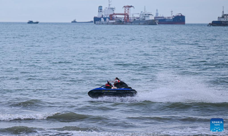 A tourist experiences a water recreation activity in Sanya Bay of Sanya, south China's Hainan Province, Aug. 30, 2023. (Xinhua/Pu Xiaoxu)