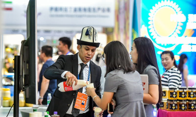 Visitors are invited to taste drinks from Kyrgyzstan at the (China) Eurasia Commodity and Trade Expo in Urumqi, Northwest China's Xinjiang Uygur Autonomous Region, on August 17, 2023. The expo is held from August 17 to 21. More than 1,300 Chinese and foreign enterprises are participating in the expo, a record high. Photo: cnsphoto