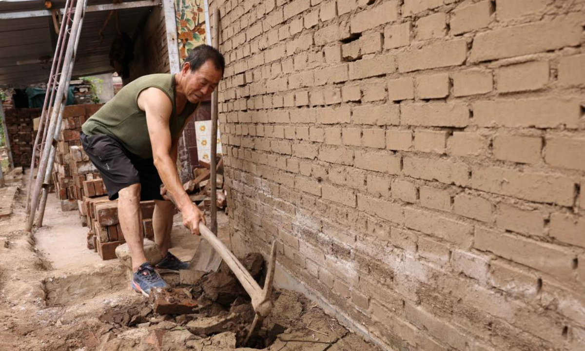 Villager Zhao Minglin cleans up a drainage ditch at Pingyu Village of Laishui County, north China's Hebei Province, Aug 17, 2023. Laishui County has suffered heavy rainfall due to the impact of Typhoon Doksuri recently. Photo:Xinhua