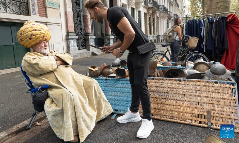 A stall owner talks with a customer during the annual Braderie de Lille (Lille flea market), in Lille, northern France, Sept. 2, 2023. The annual Braderie de Lille kicked off here on the first weekend of September. (Photo by Sebastien Courdji/Xinhua)