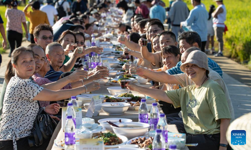 This photo taken on Sept. 2, 2023 shows people taking part in a long-table banquet in Xinglong Village, Yanbian County of southwest China's Sichuan Province. (Xinhua/Jiang Hongjing)